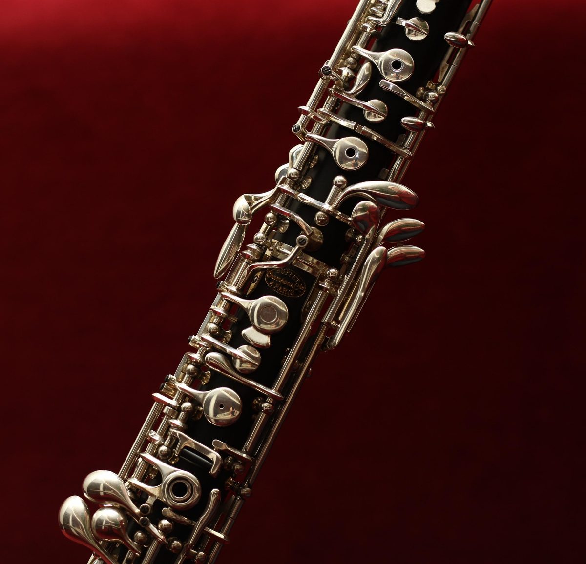 Klappenmechanik einer Oboe vor rotem Hintergrund